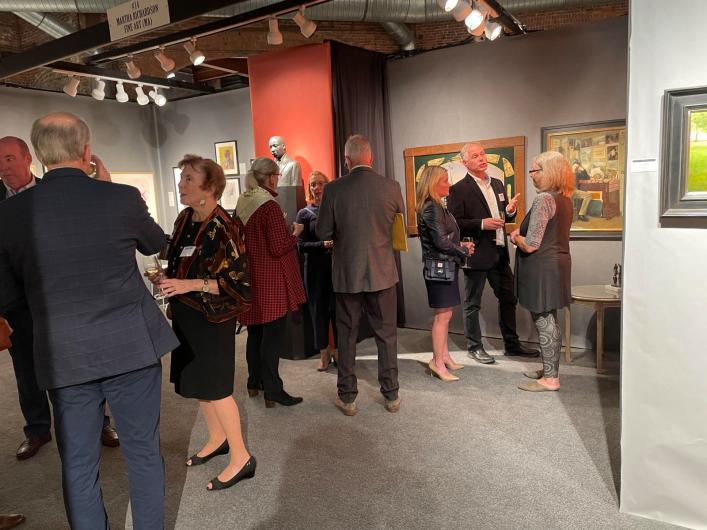 People chat in exhibitor booth